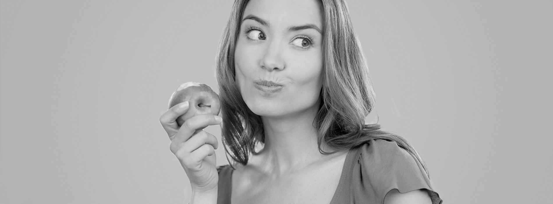 Jeune femme avec une pomme à la main et des gencives saines